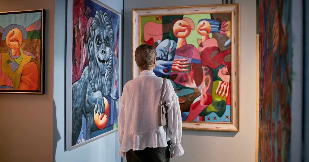 Picture of a visitor at a gallery viewing a colourful modern painting